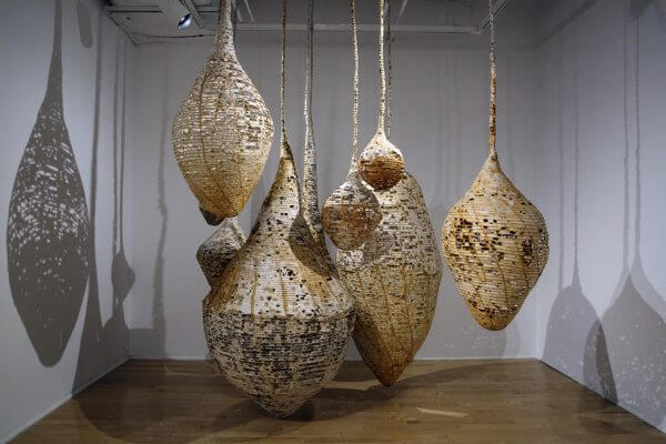 An installation of hanging sculptures made from handmade paper