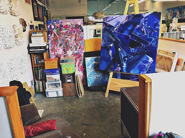 Large close-up paintings of flowers and crystals in an artist's studio