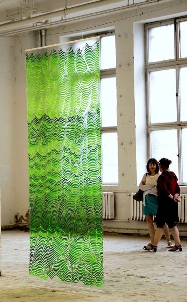 A lime green hanging installation of plastic
