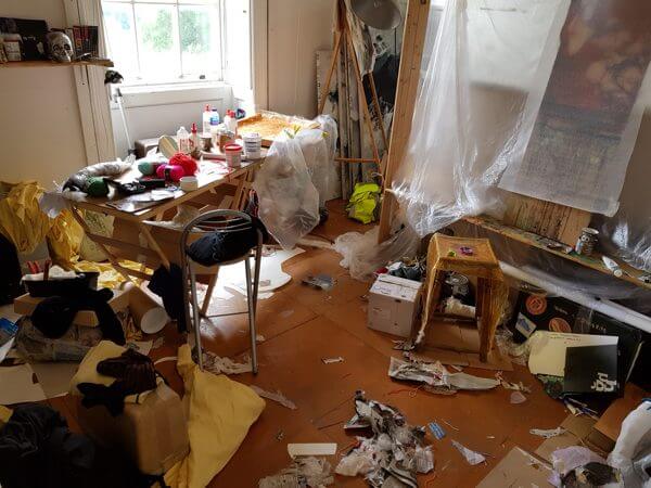 Mixed media materials clutter an artist's studio space