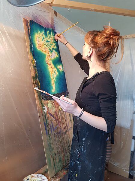 An artist works on an abstract painting in her studio