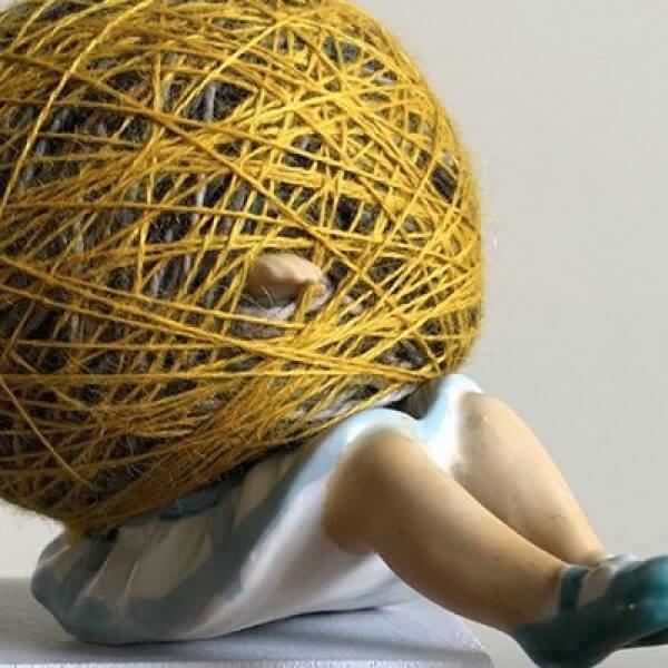 scultpure by of a woman caught in a ball of string