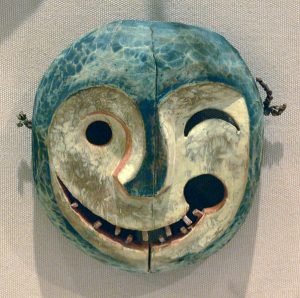 An Alaskan mask making a winking face