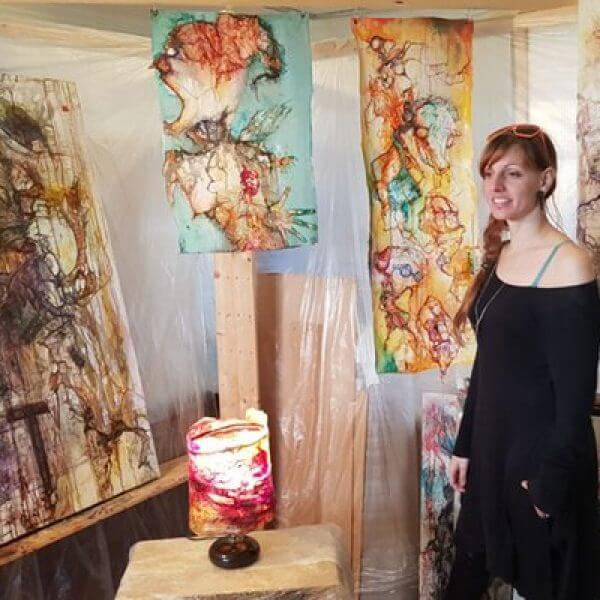 An artist in her studio of abstract mixed media wall hangings