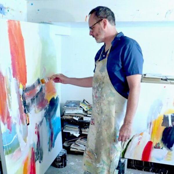 A painter works on a canvas in his studio