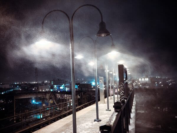 A photograph of a foggy dock at night, lit by streetlamps