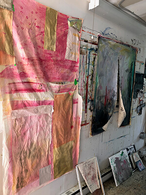 Hanging paintings on canvas in an artist's studio