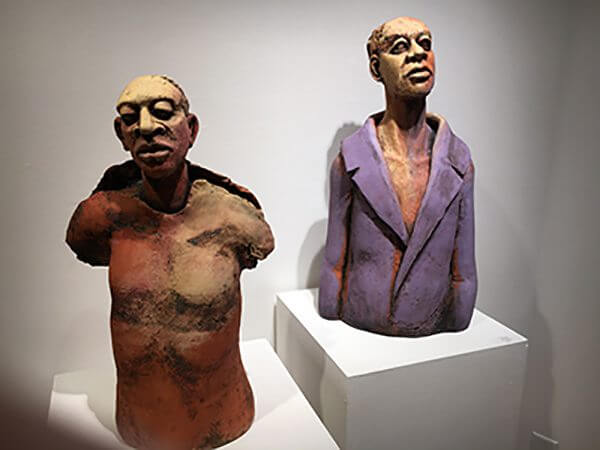 Clay sculptures of human heads on abstracted figures