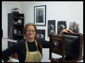 Portrait of photographer Laura J. Bennett with her camera and work 