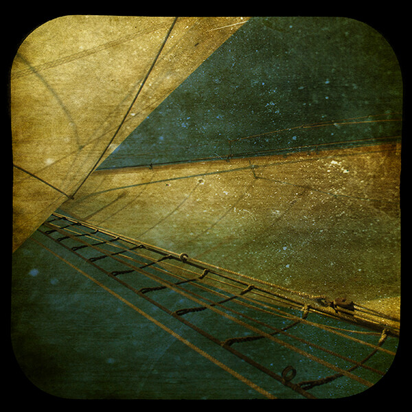 Edited photograph of the mast of a sailboat among a dark background