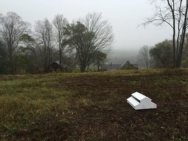 The model of a barn on a hill where it will be built