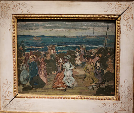 A painting of people walking along a beach, in a gold and white frame
