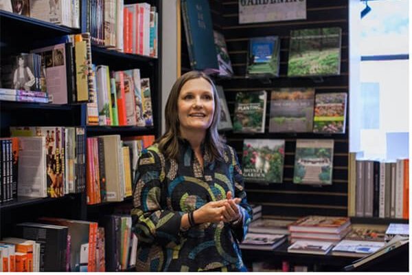 A writer gives a talk at a bookstore in front of shelves