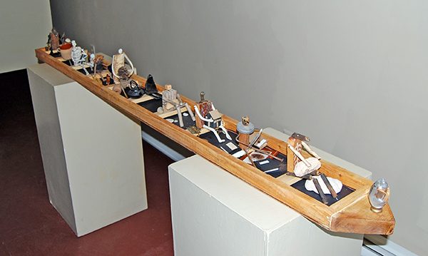 Found object sculpture of a group of wooden figures in a boat