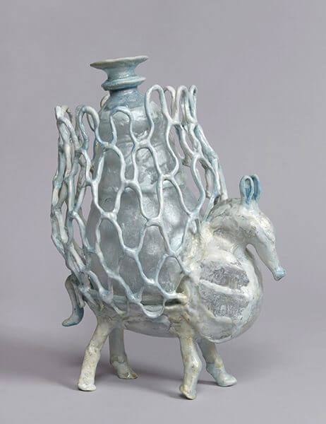 Sculpture of a horse-like animal with a netted vase on top