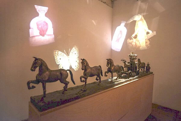 a bronze processional sculpture of horses and a wagon