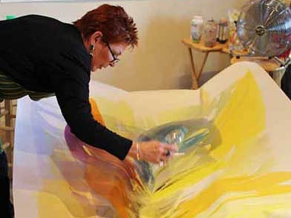 Bette Ridgeway pouring paint in her studio