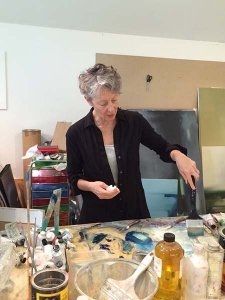 Artist Liz Dexheimer painting in her studio.