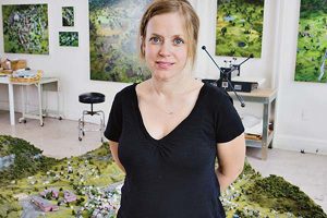 Amy Bennett in her studio, with her miniature models and paintings