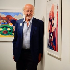Painter George Casprowitz in front of his colorful paintings
