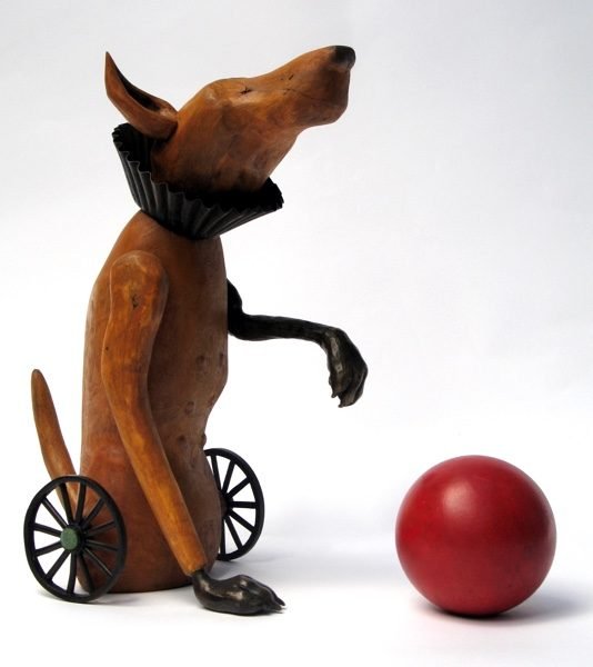 Wooden sculpture of a dog with his ball