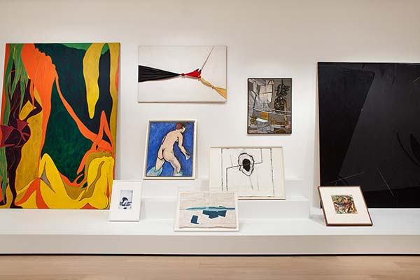 Installation view of Shape on Shape, abstract paintings and drawings lining a shelf and gallery walls