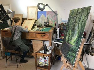 Artist drawing trees at a workman's desk