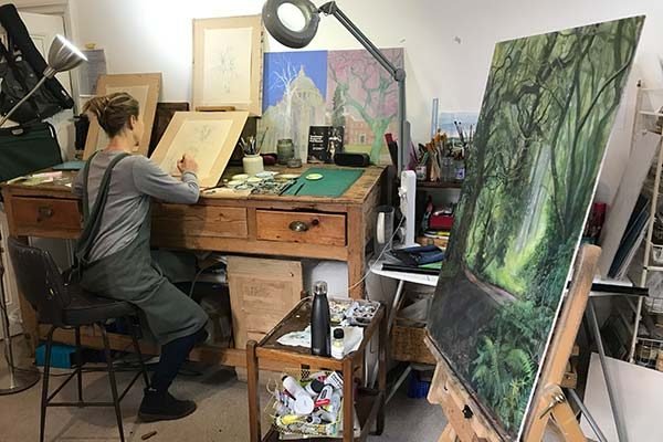 Artist drawing trees at a workman's desk