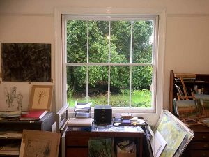 An art studio window overlooking a large oak tree