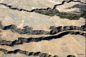 An aerial photograph of dry earth with fissures