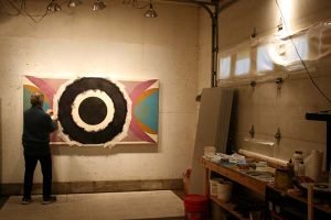 A painter works on his painting in a garage studio