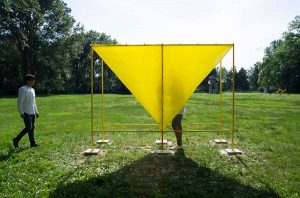 A bright yellow latex sheet, an interactive sculpture installed in a park