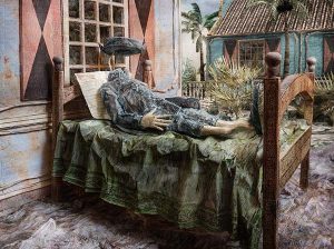 A staged photograph of a headless soldier laying in a bed