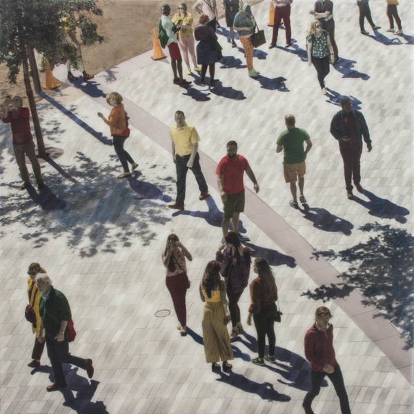 A photograph of people walking along a square