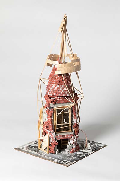 A sculpture of a brick and wood chimney under construction