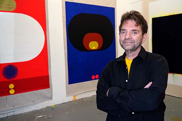 Painter Tom Martinelli poses with his work