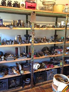 Found objects line the shelves of an artist's studio