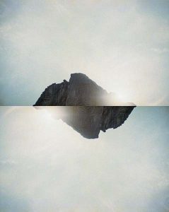A photocollage of a mountain reflected against itself