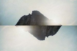 A photocollage of a mountain reflected against itself