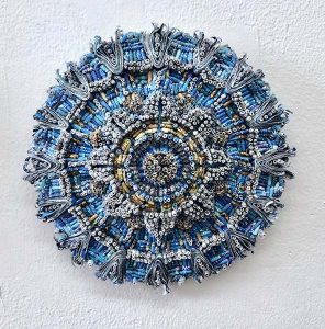 A blue, orb-shaped piece of artwork made from tightly wound pieces of paper