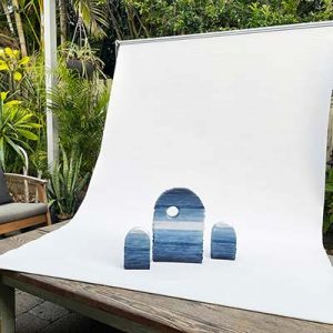 Make-shift photo studio using a thrift shop roller blind as a backdrop for documenting artworks.