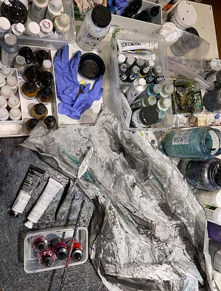 Yaniv's studio table holds paints, material, and other necessary tools.