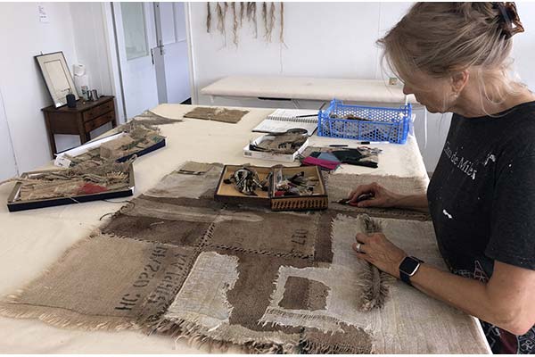 Fiber artist Janet Jaffke works on burlap and gauze in her studio, a converted thread factory close to the border of Germany and France.